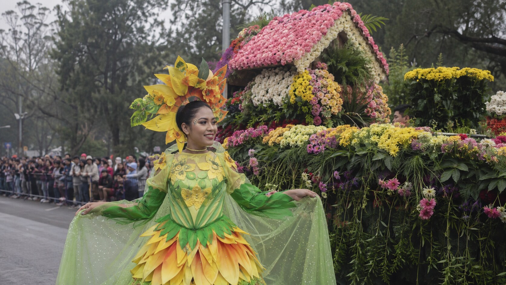 Panagbenga Festival performer beside a floral float in Baguio City